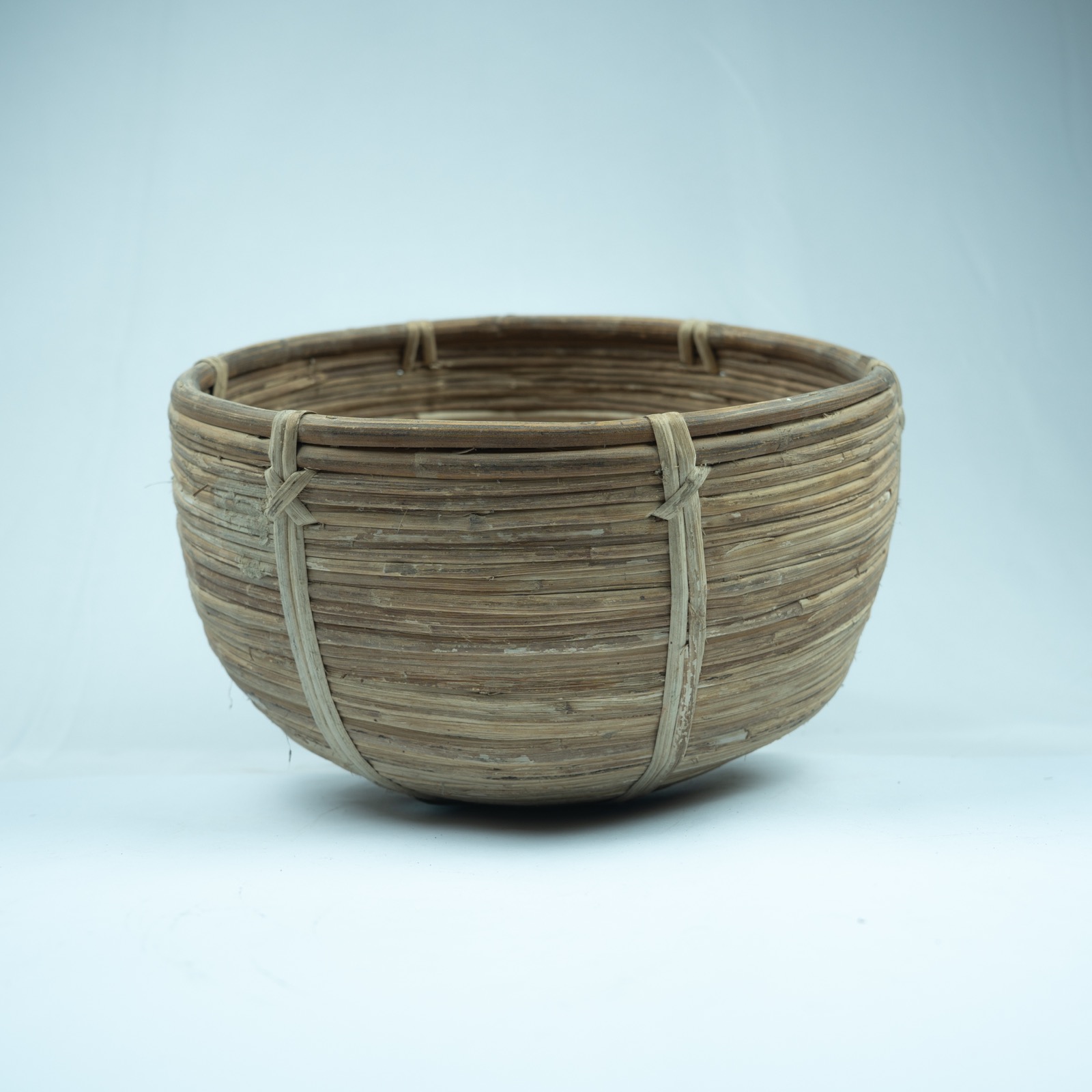 Natural woven rattan basket with rounded sides and warm neutral texture